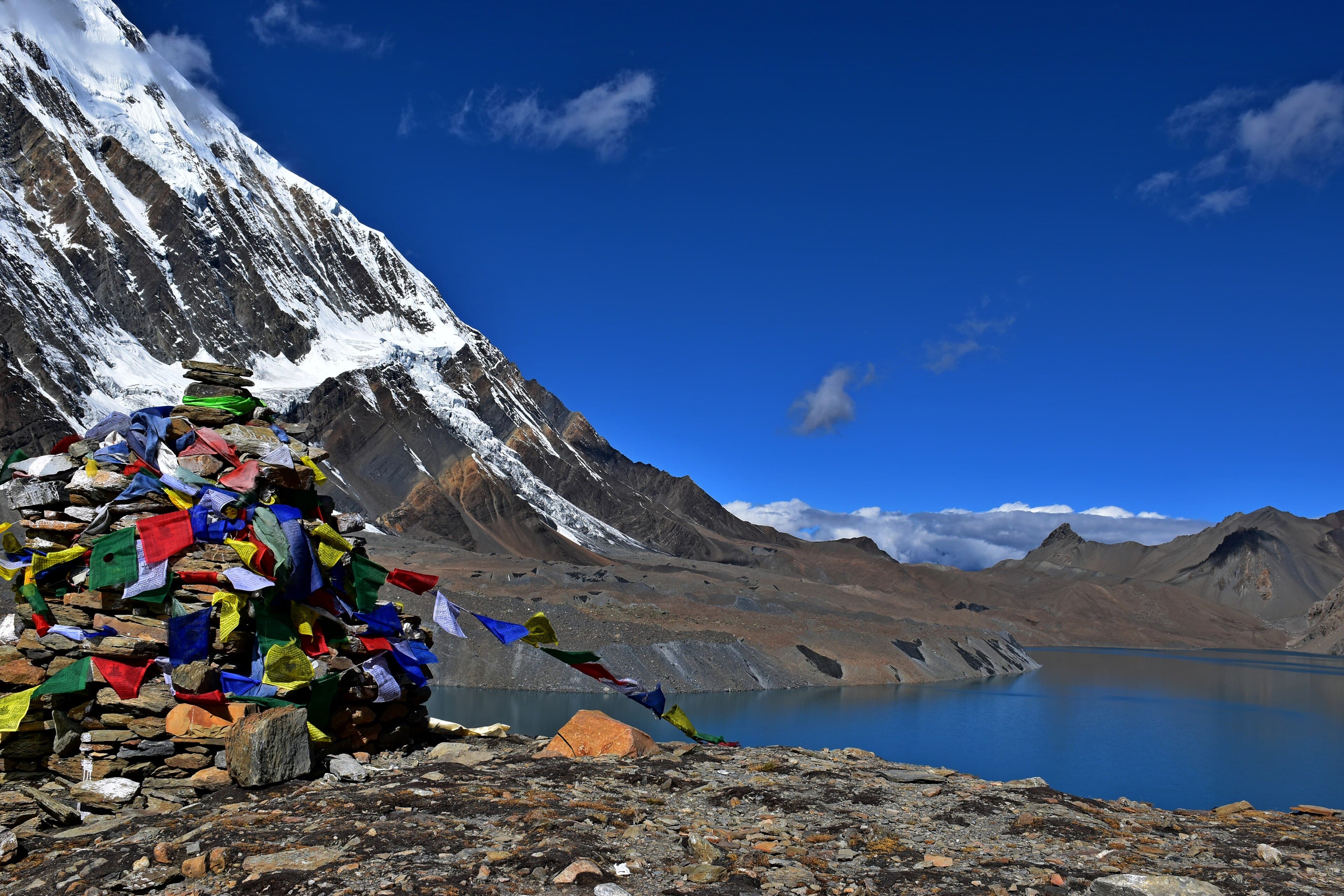 Prayer flags above Tilicho Lake with Tilicho Peak behind